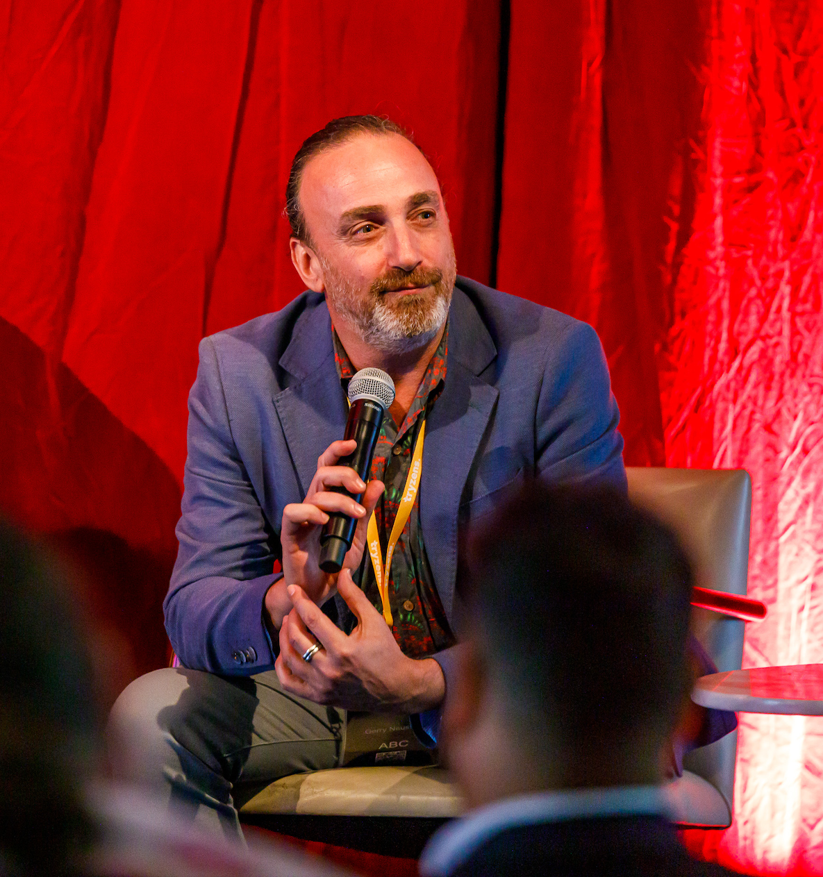 Gerry, seated, holds a microphone